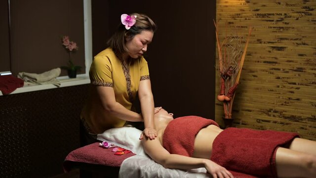 Massage parlor in Tysons Corner with a professional therapist giving a relaxing arm massage to a client in a calm, spa-like treatment room.
