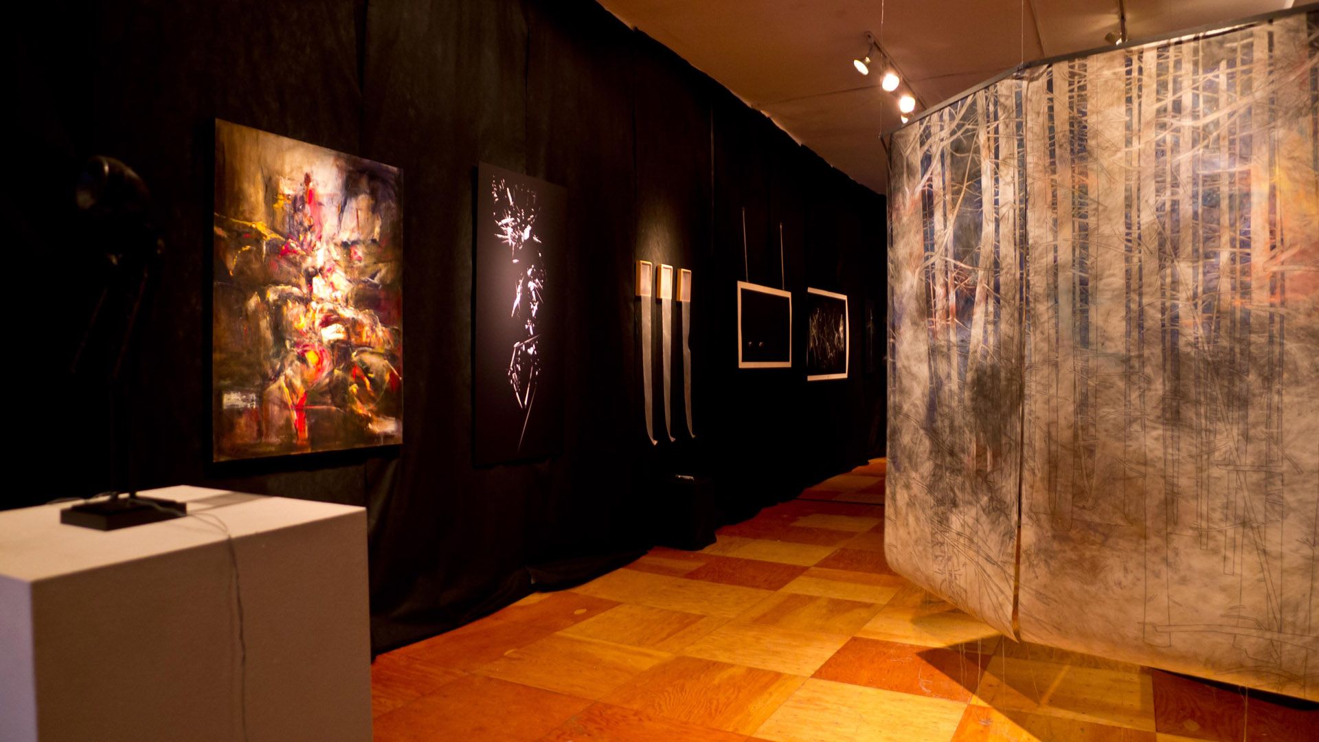 Contemporary art gallery interior with abstract paintings and mixed-media installations displayed under warm lighting, showcased as part of visual inspiration for a Massage parlor in Tysons Corner.